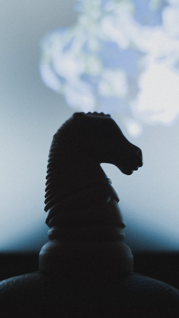 Moody silhouette of a chess knight with a blurred background, evoking strategic contemplation.